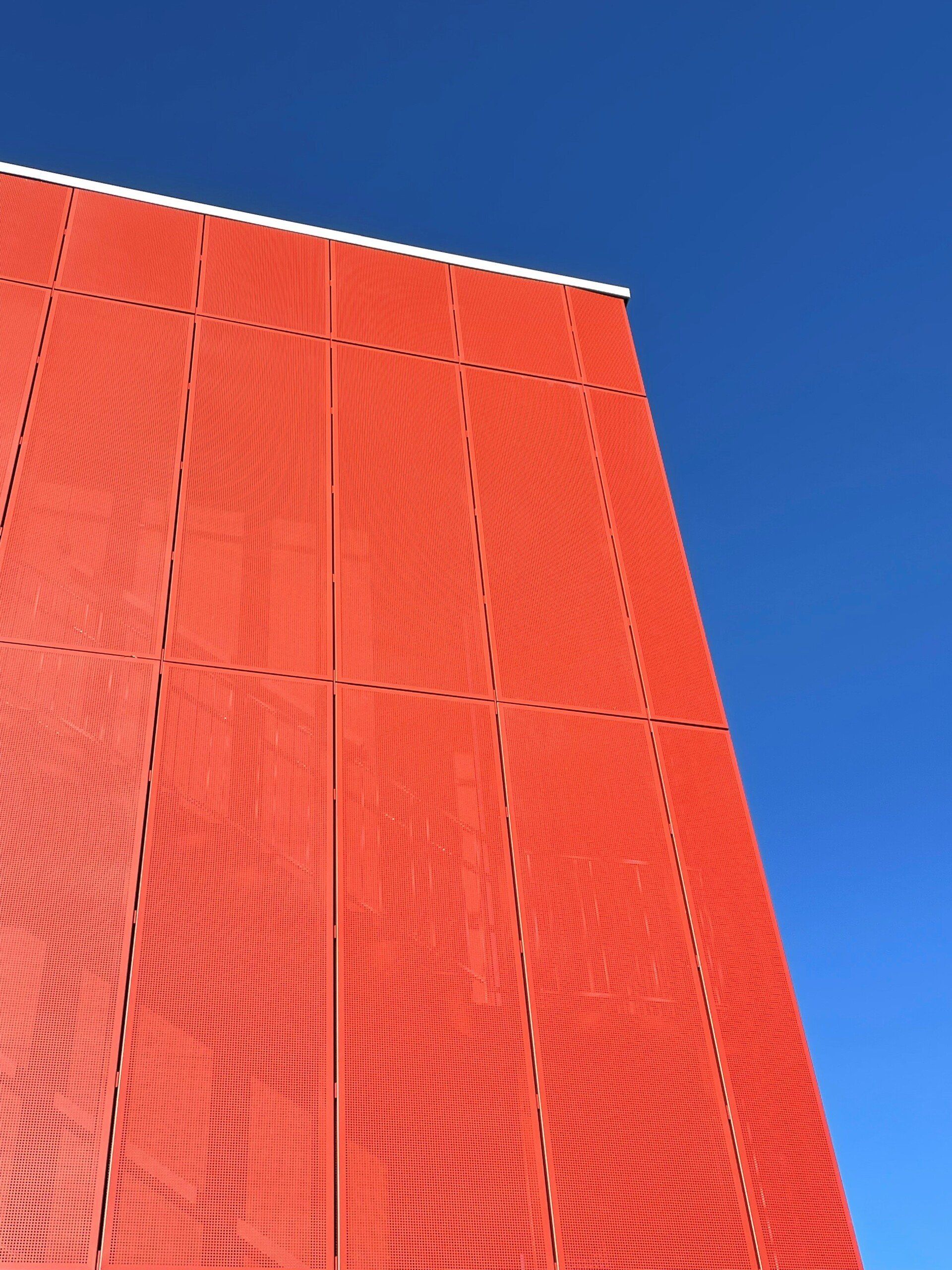 A red building with a blue sky in the background