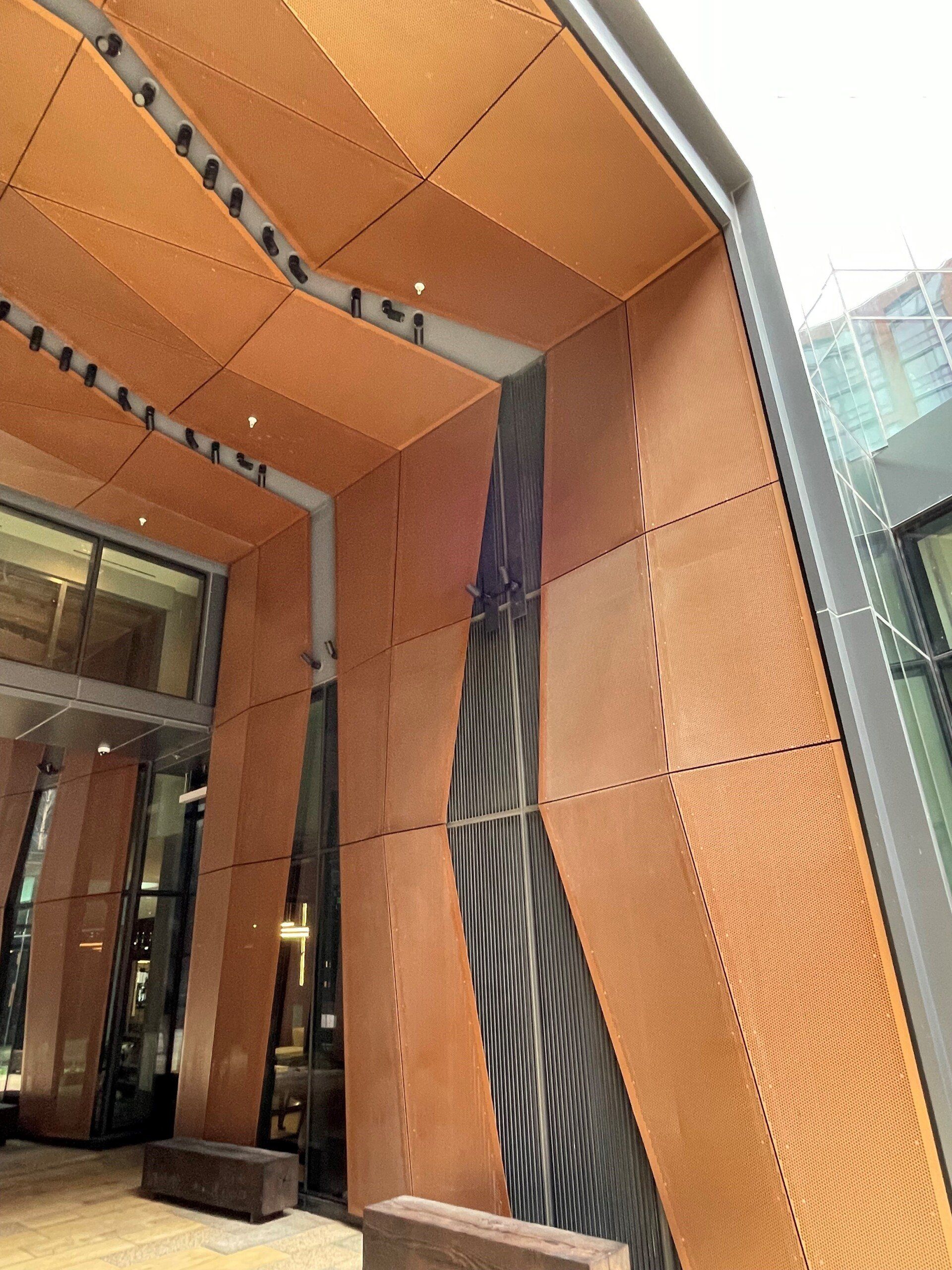 A building with a wooden roof and a bench in front of it