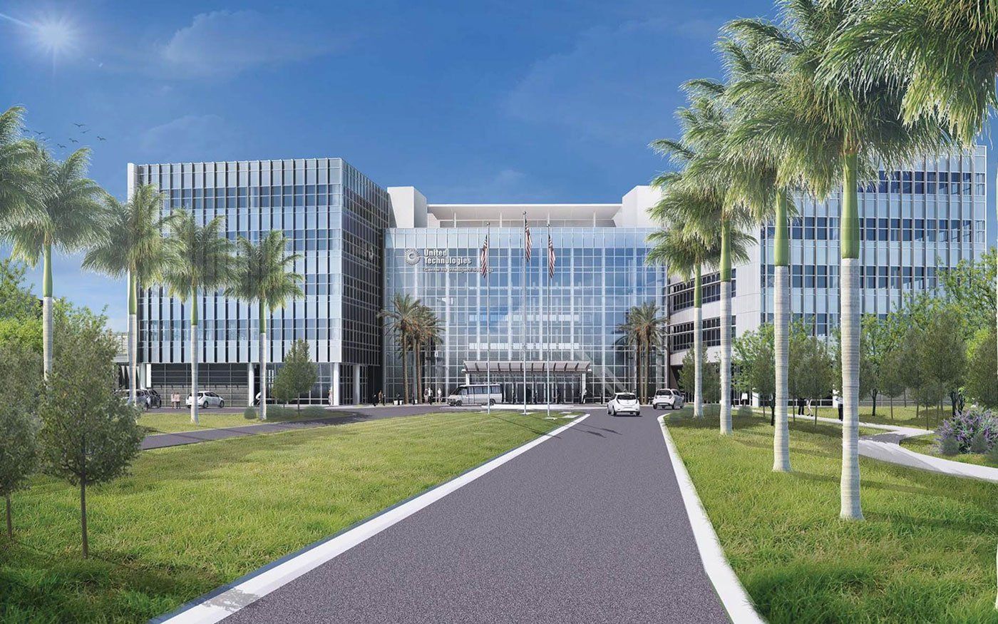 A large building with a lot of windows is surrounded by trees and grass.