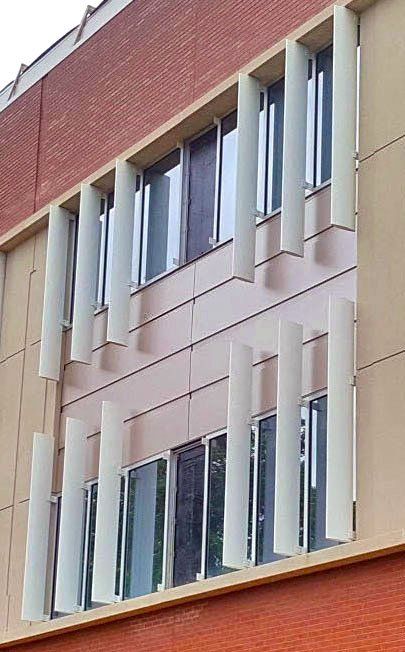 A building with a lot of windows and columns on the side of it.