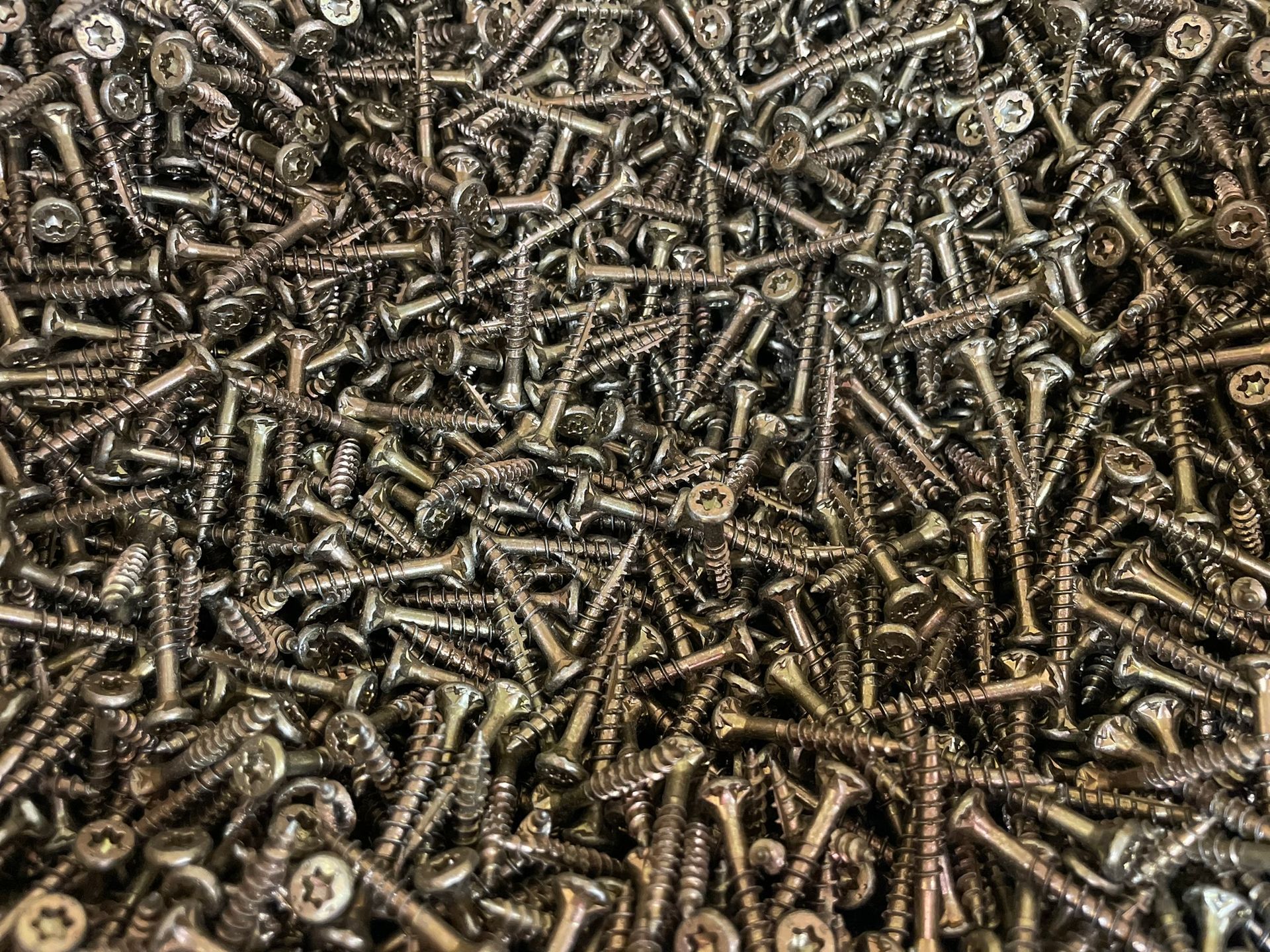 A pile of screws sitting on top of each other on a table.