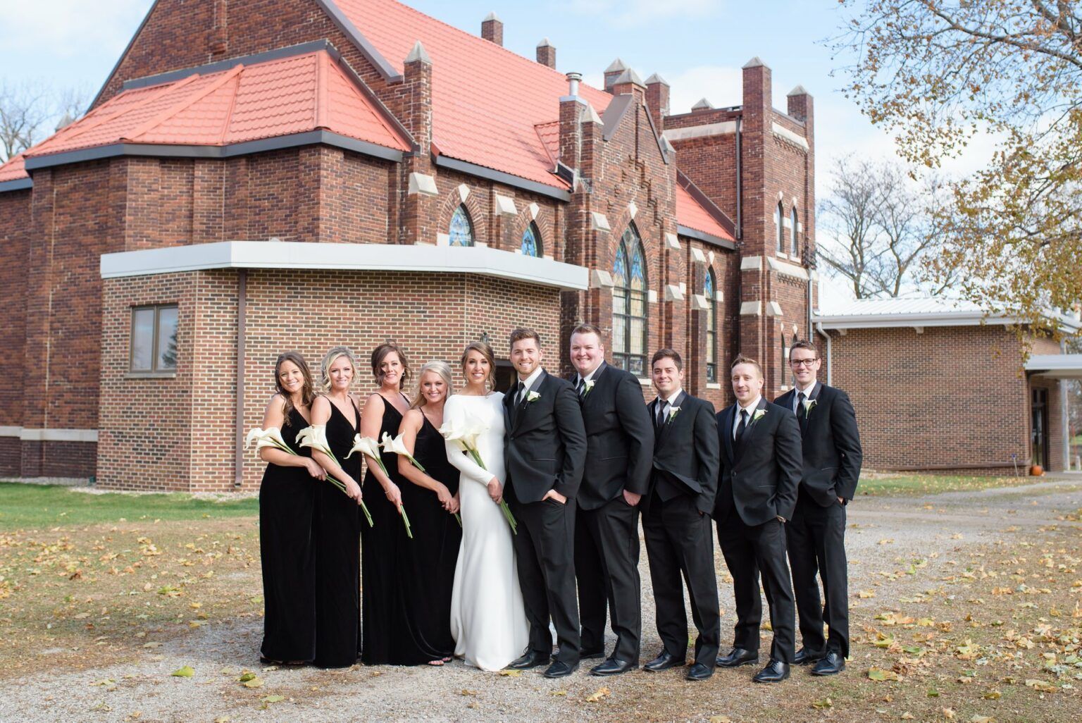 Bride and groom kissing, groom dipping bride on a street, autumn setting.