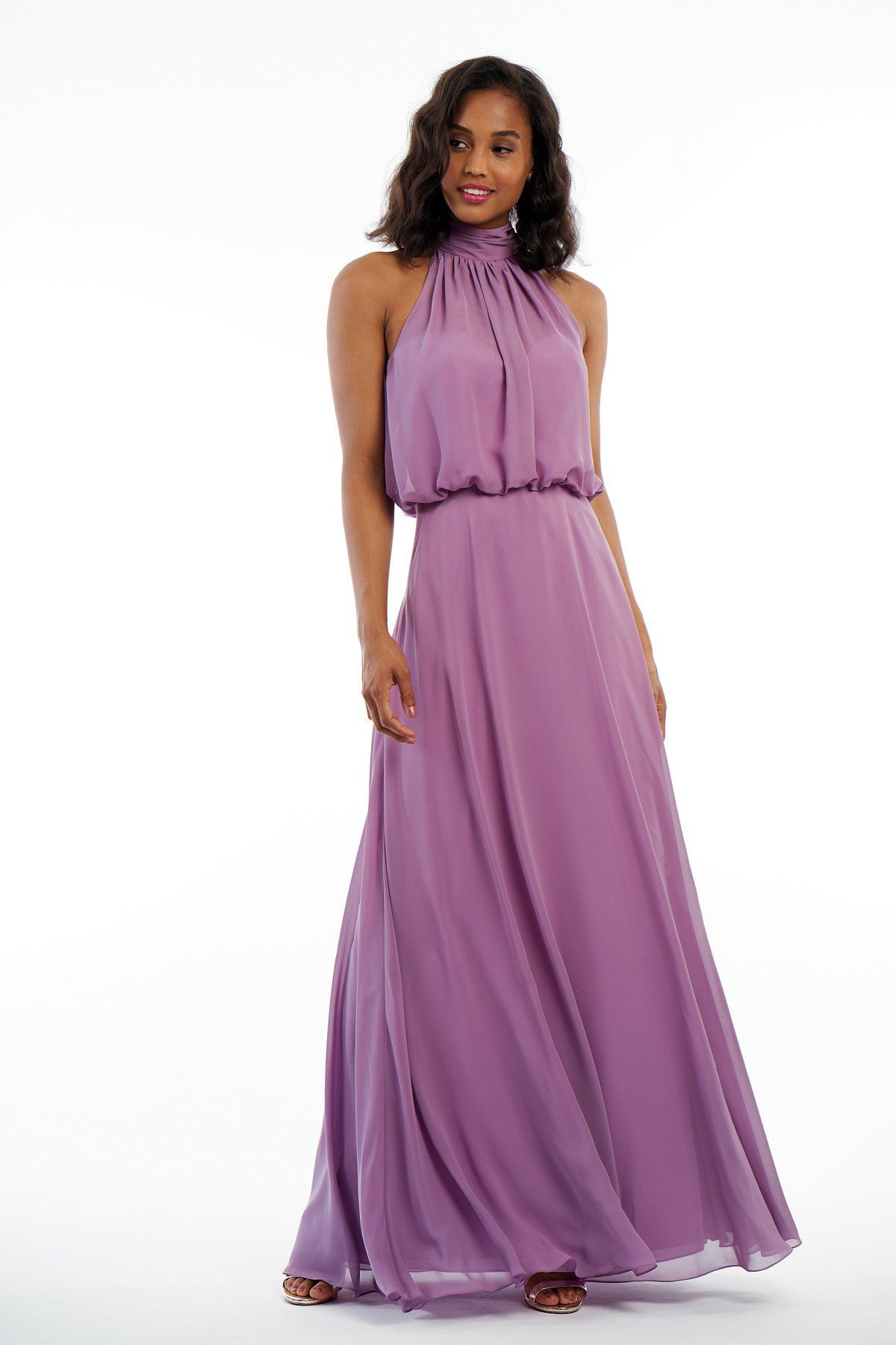 Woman in a lilac halter neck maxi dress, standing with arms at sides.
