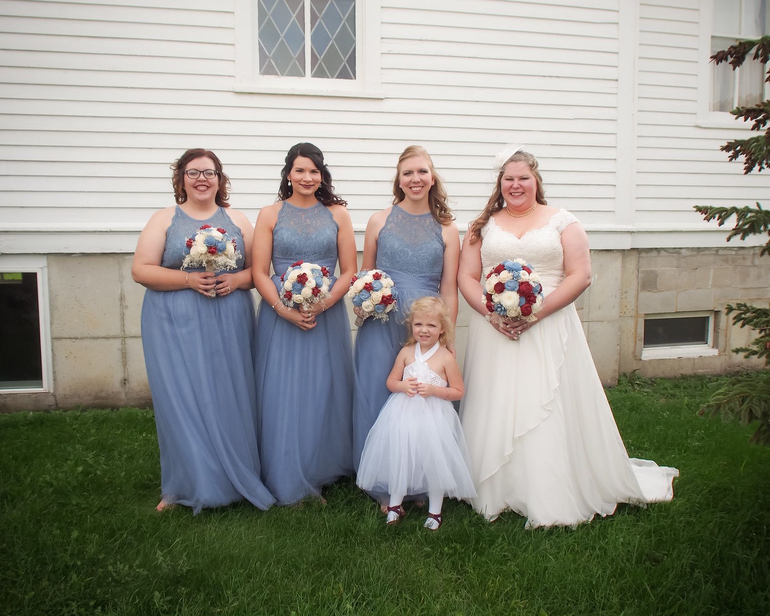 Woman in a white off-shoulder wedding dress smiles in a bridal shop.