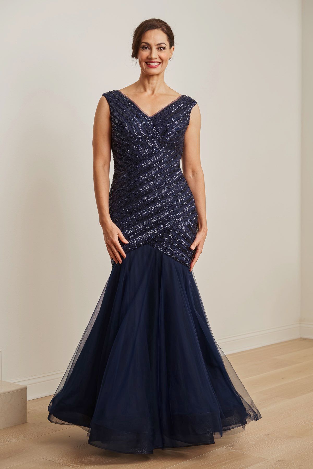 Woman in navy sequined gown with a mermaid skirt.