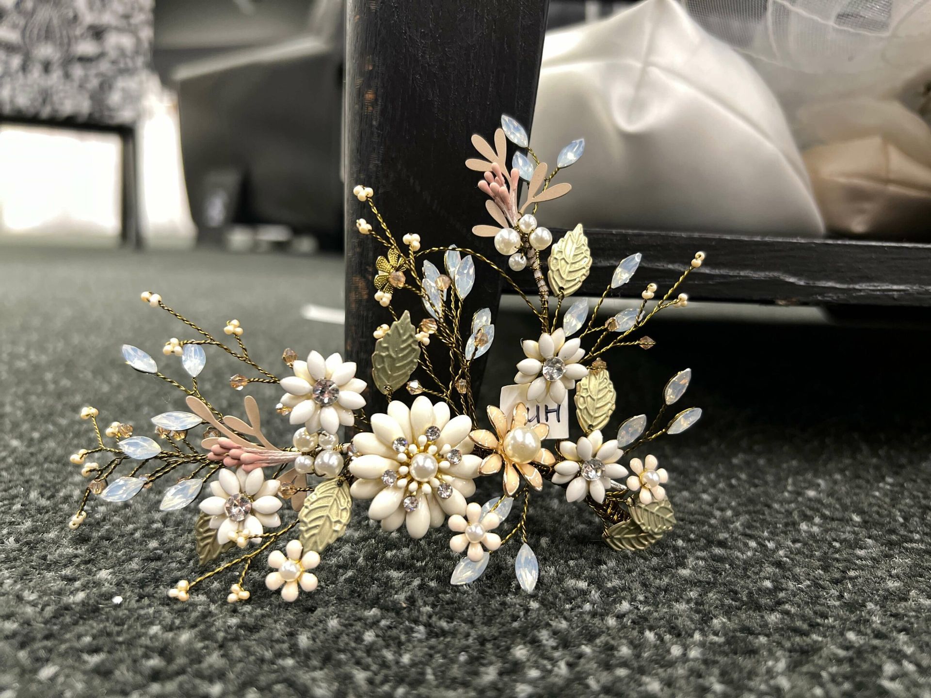 Floral hair accessory with white and gold flowers, light blue crystals, and gold leaves.