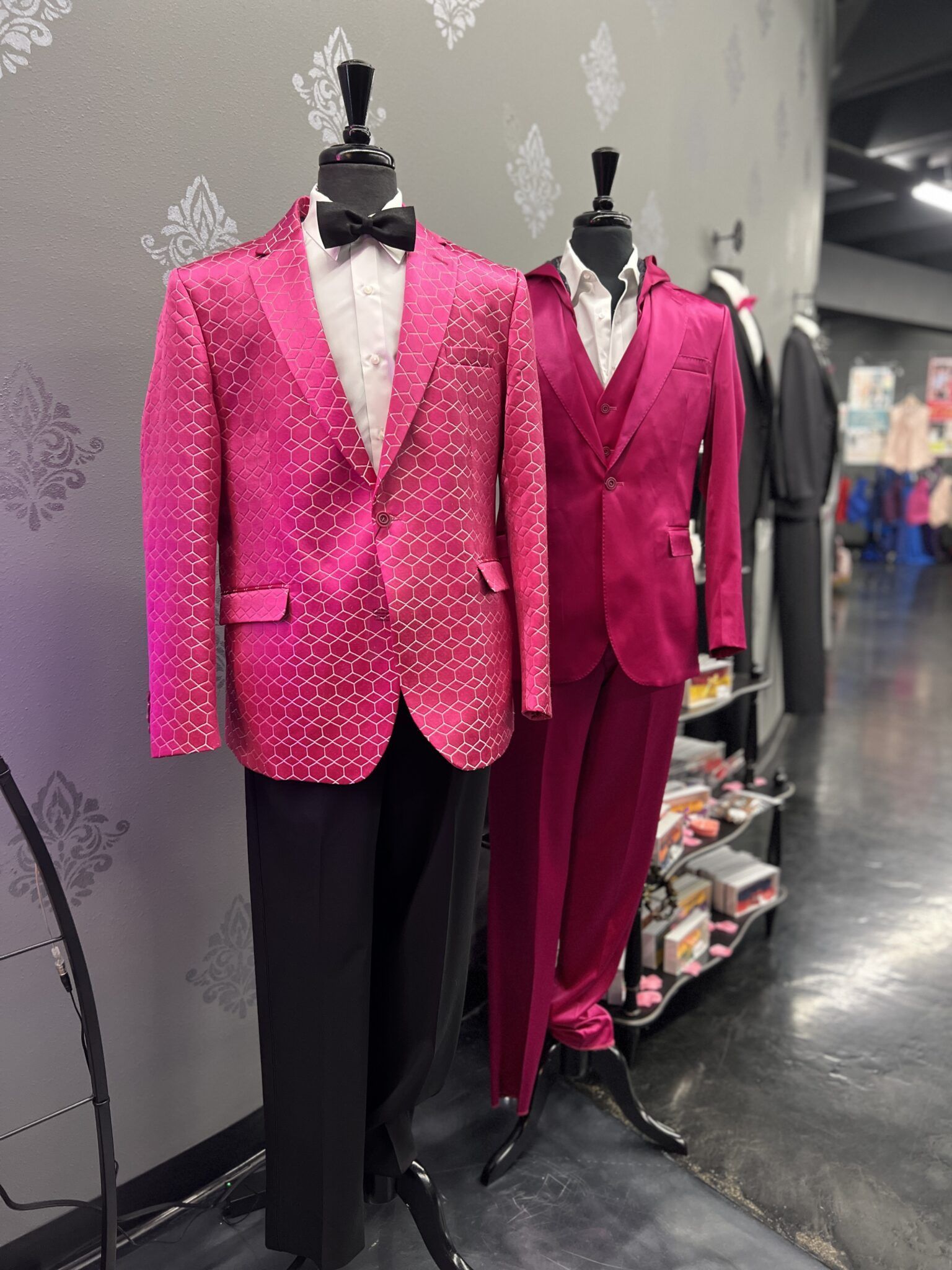 Woman in a white off-shoulder wedding dress smiles in a bridal shop.