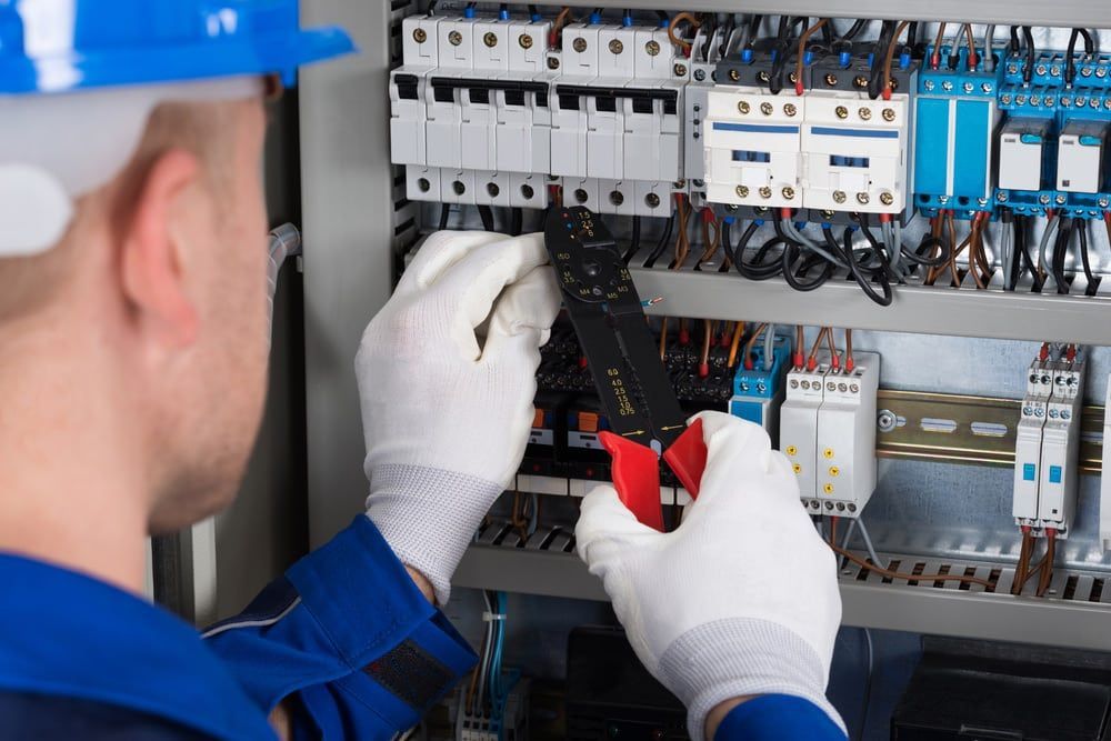 Electrician Working on a Control Panel With Pliers, White Gloves — Ralph Ottmann Electrical in Pomona, QLD