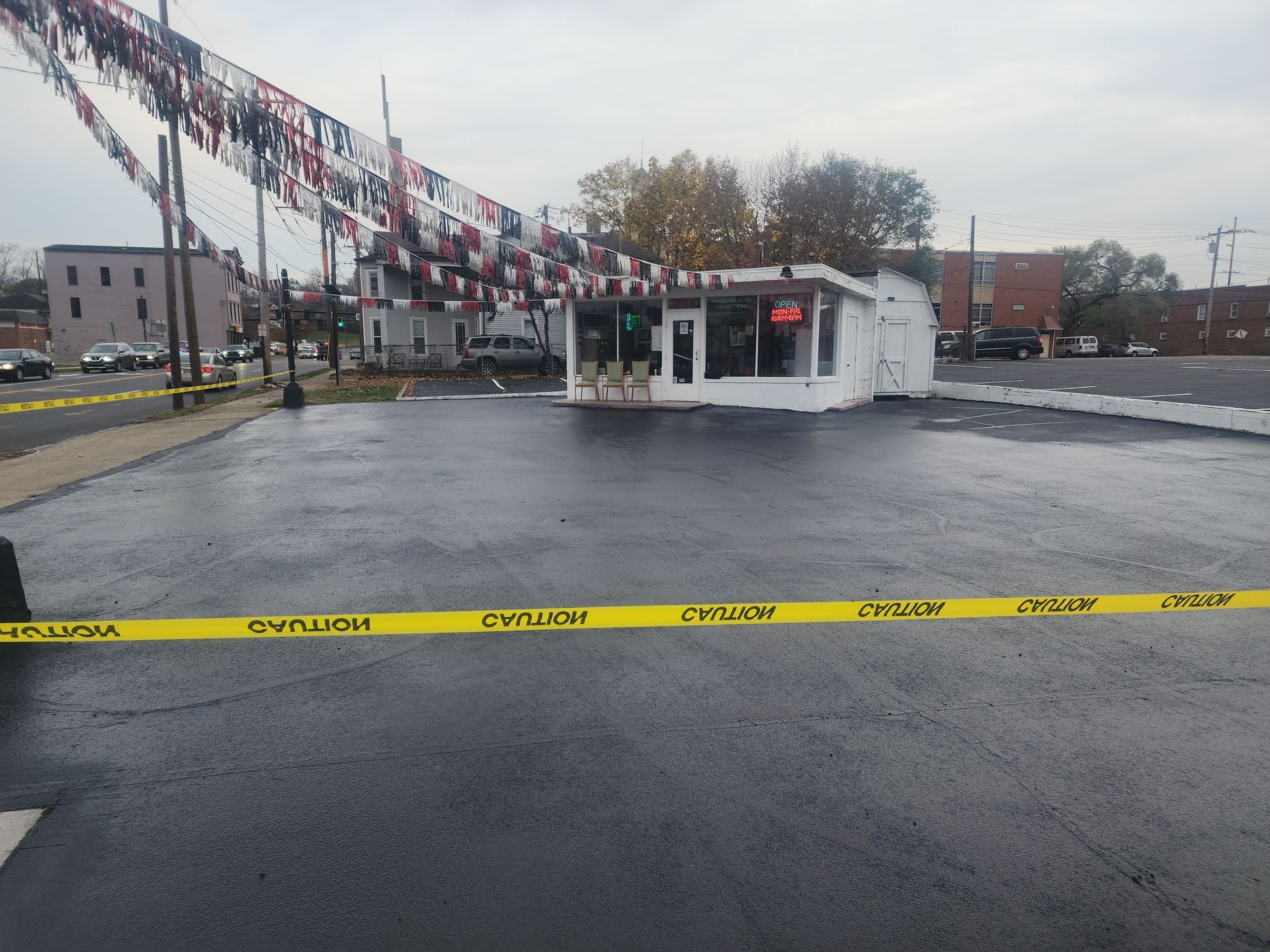 A car dealership is surrounded by yellow tape