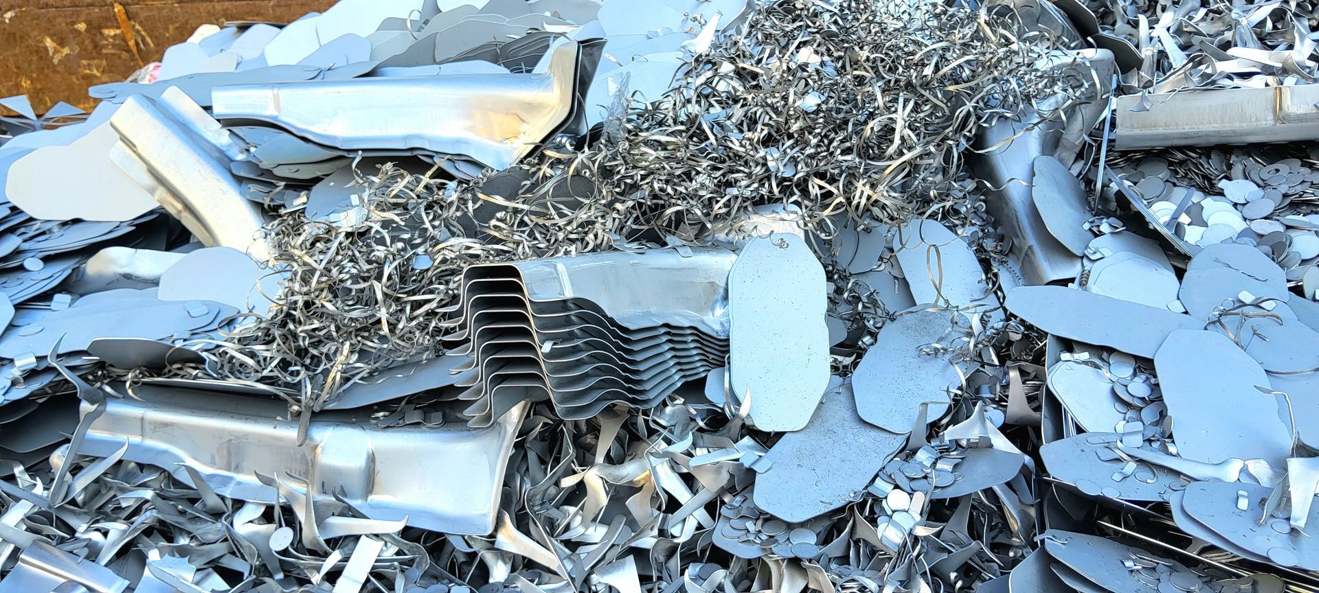 Close-up of a scrap metal pile with copper wire, aluminum shavings, and mixed non-ferrous metals Close-up of a scrap metal pile with copper wire, aluminum shavings, and mixed non-ferrous metals