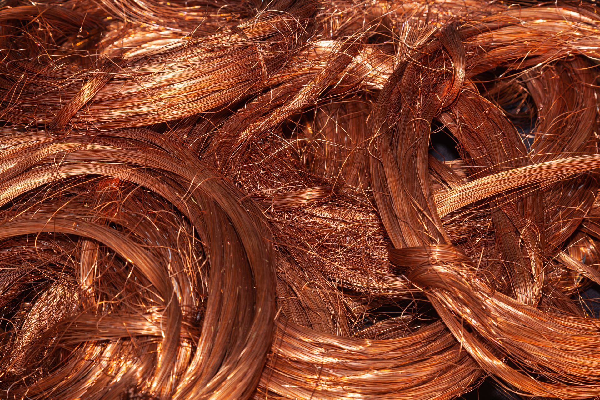 Copper scrap metal wires piled together, showing twisted strands and bright metallic texture.