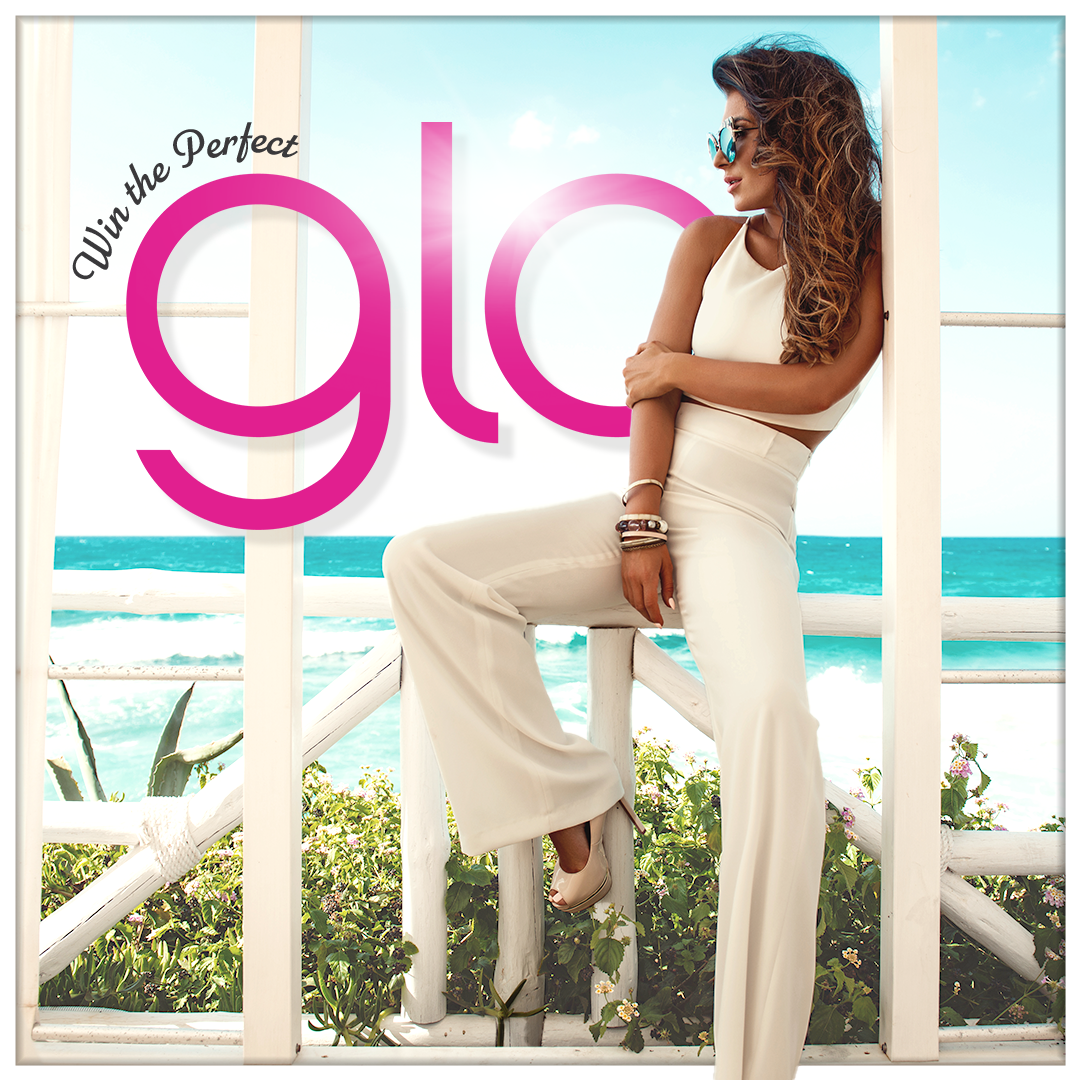A woman is sitting on a railing in front of a sign that says glo