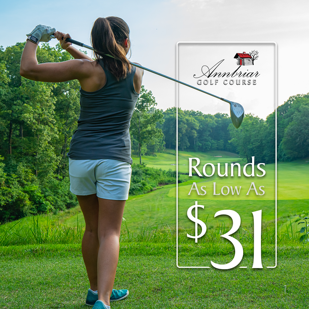 A woman is swinging a golf club on a golf course.