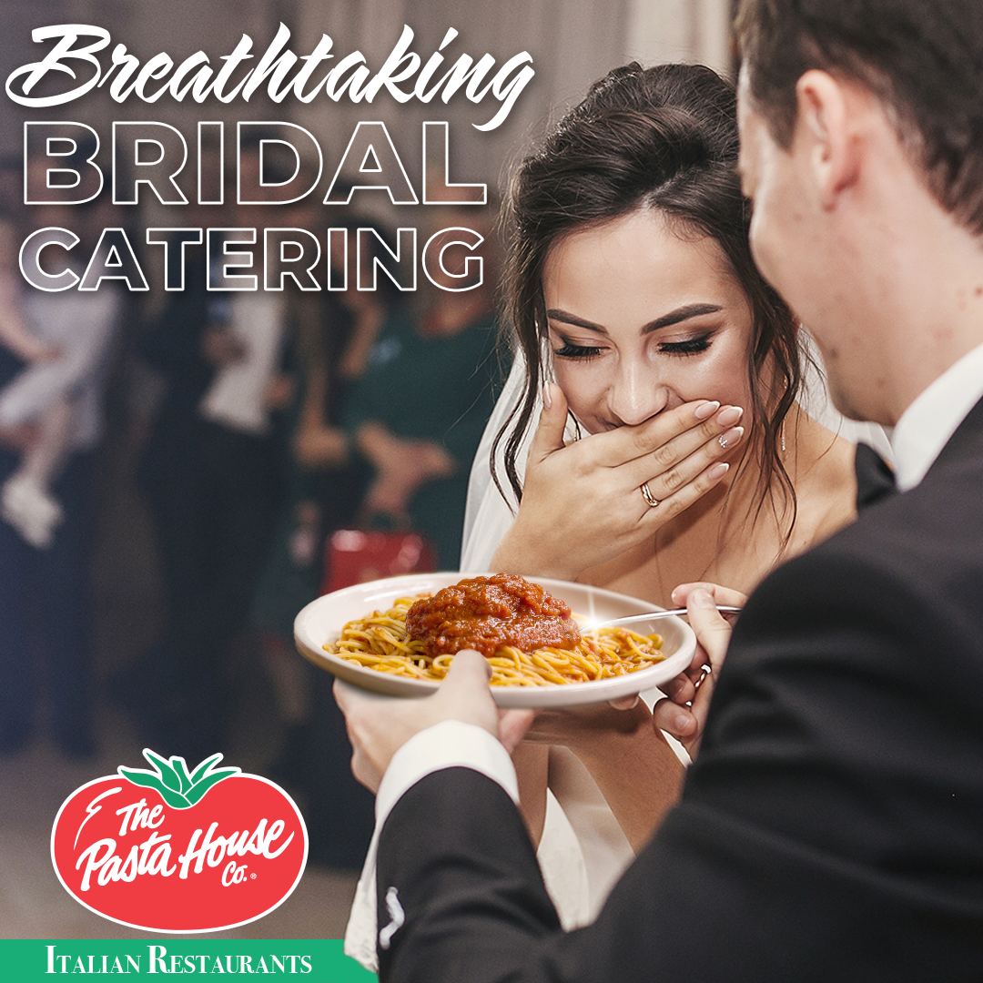 A bride and groom are eating spaghetti at the pasta house