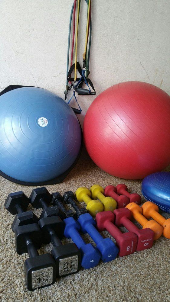 A bunch of dumbbells and a pilates ball are on the floor