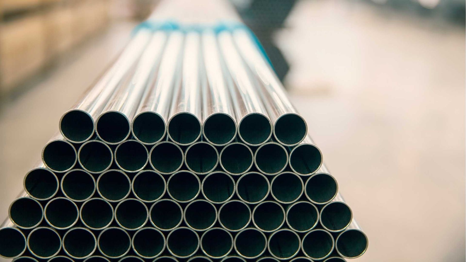A stack of metal pipes stacked on top of each other in a factory.