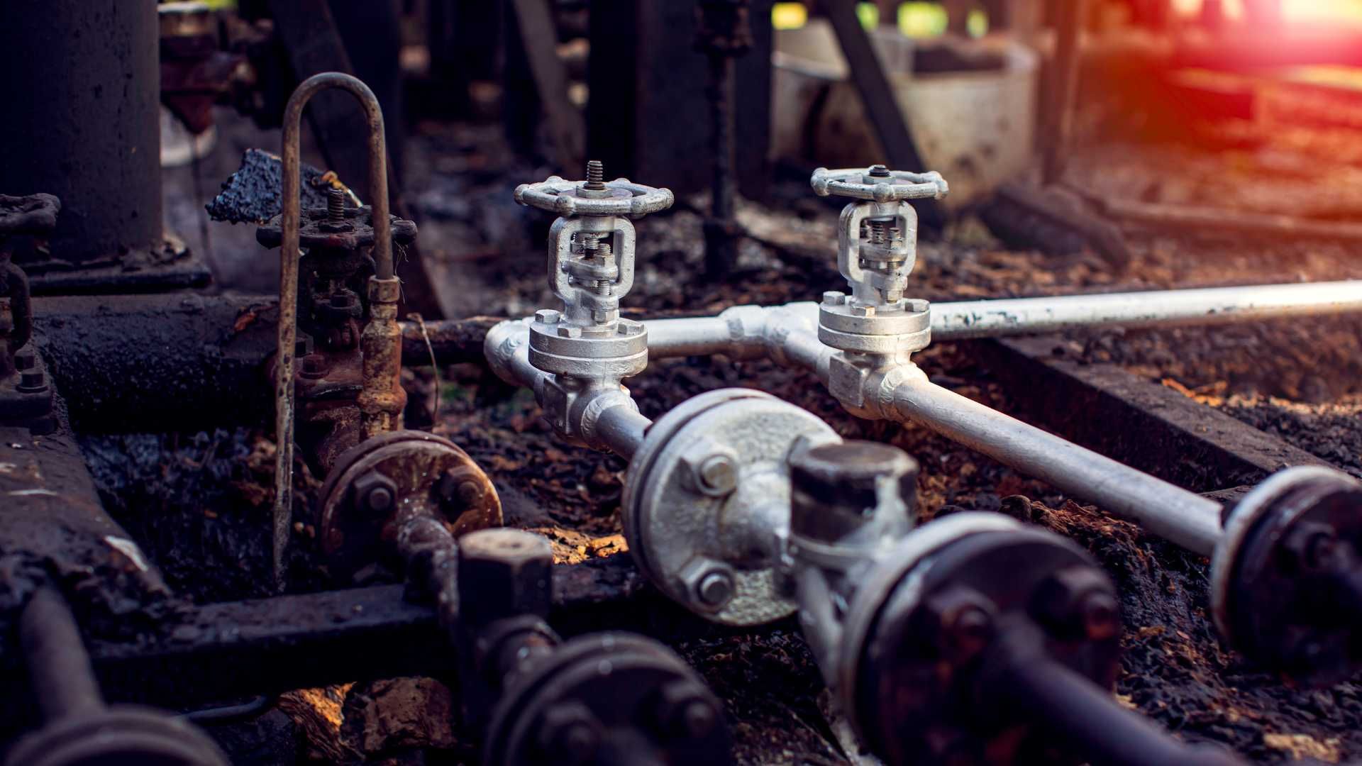 A close up of a bunch of pipes and valves in a factory.