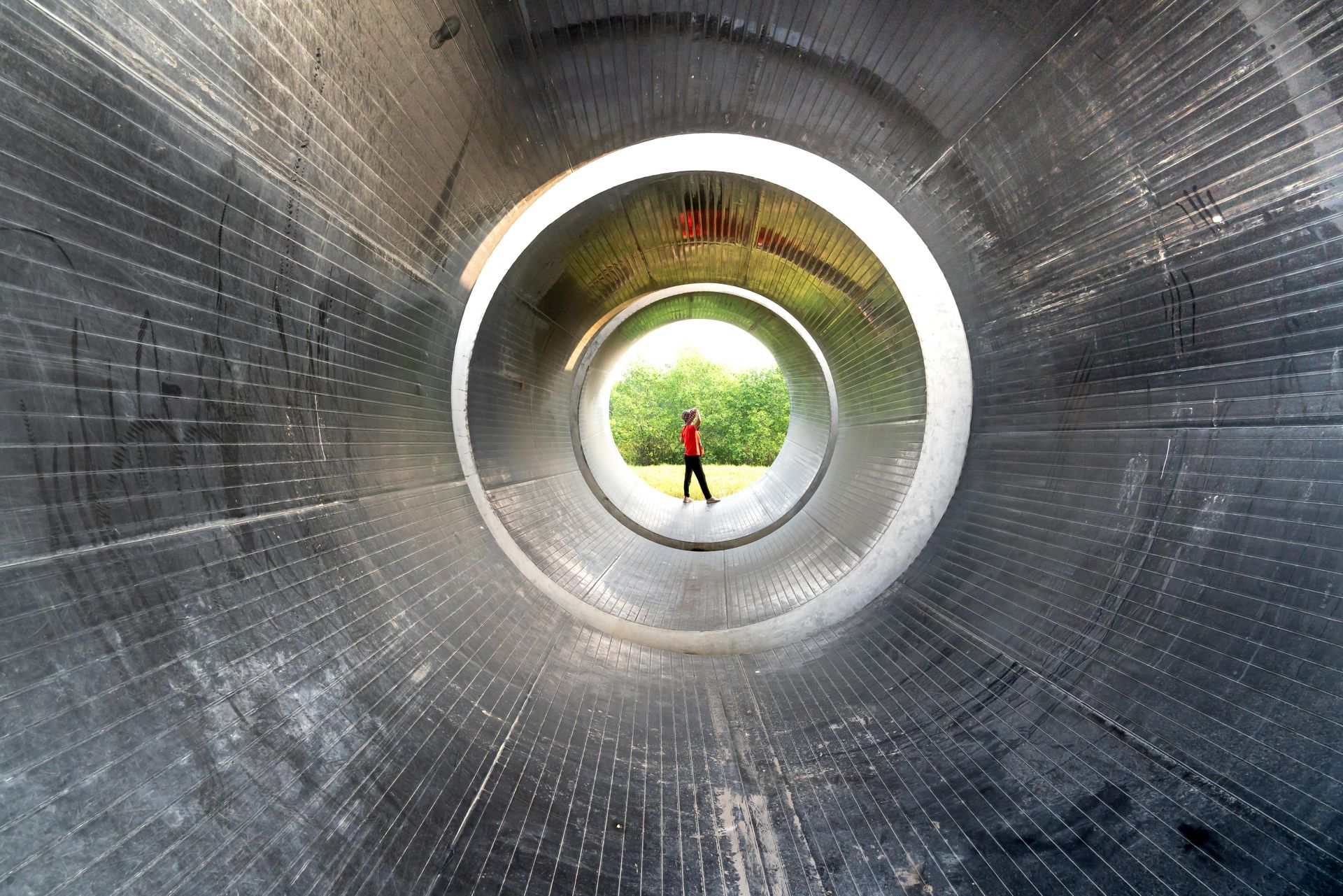 A person is walking through a tunnel with a hole in the middle.