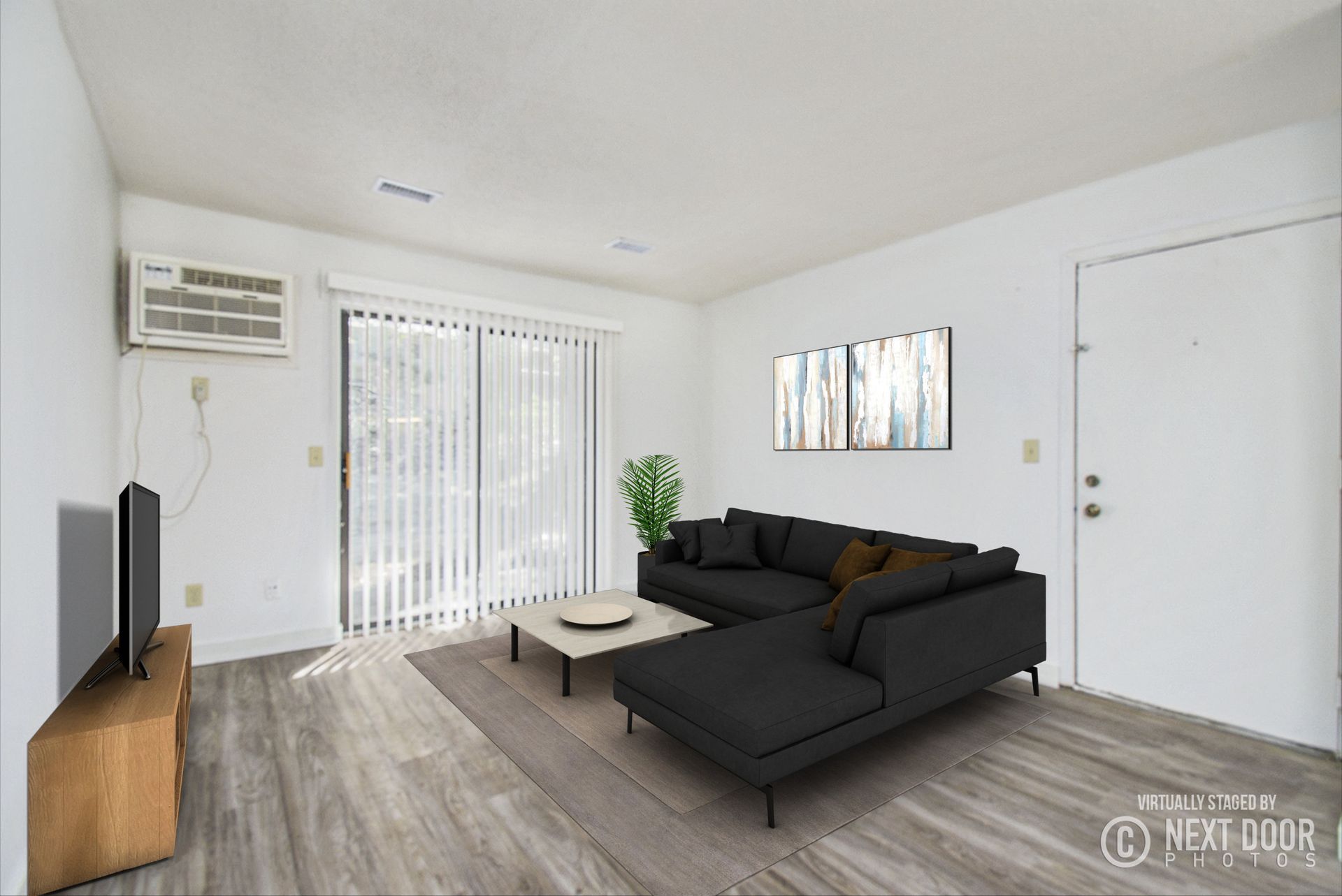 Living room with a dark sectional, sliding glass door, and a television.