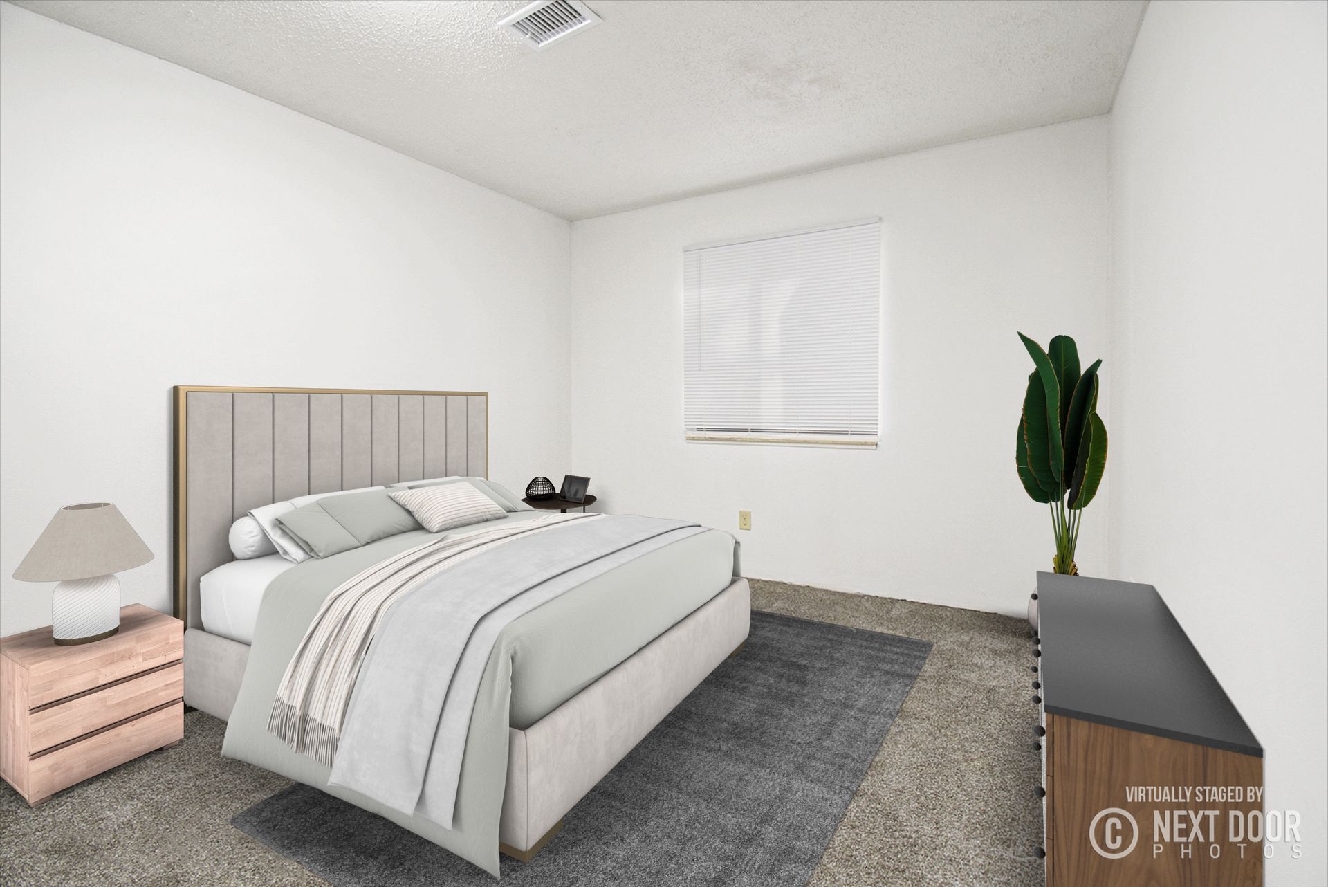 Bedroom with bed, nightstand, dresser, window with blinds, and plant.