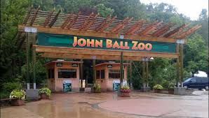 John Ball Zoo entrance with ticket booths, wooden pergola, and sign.