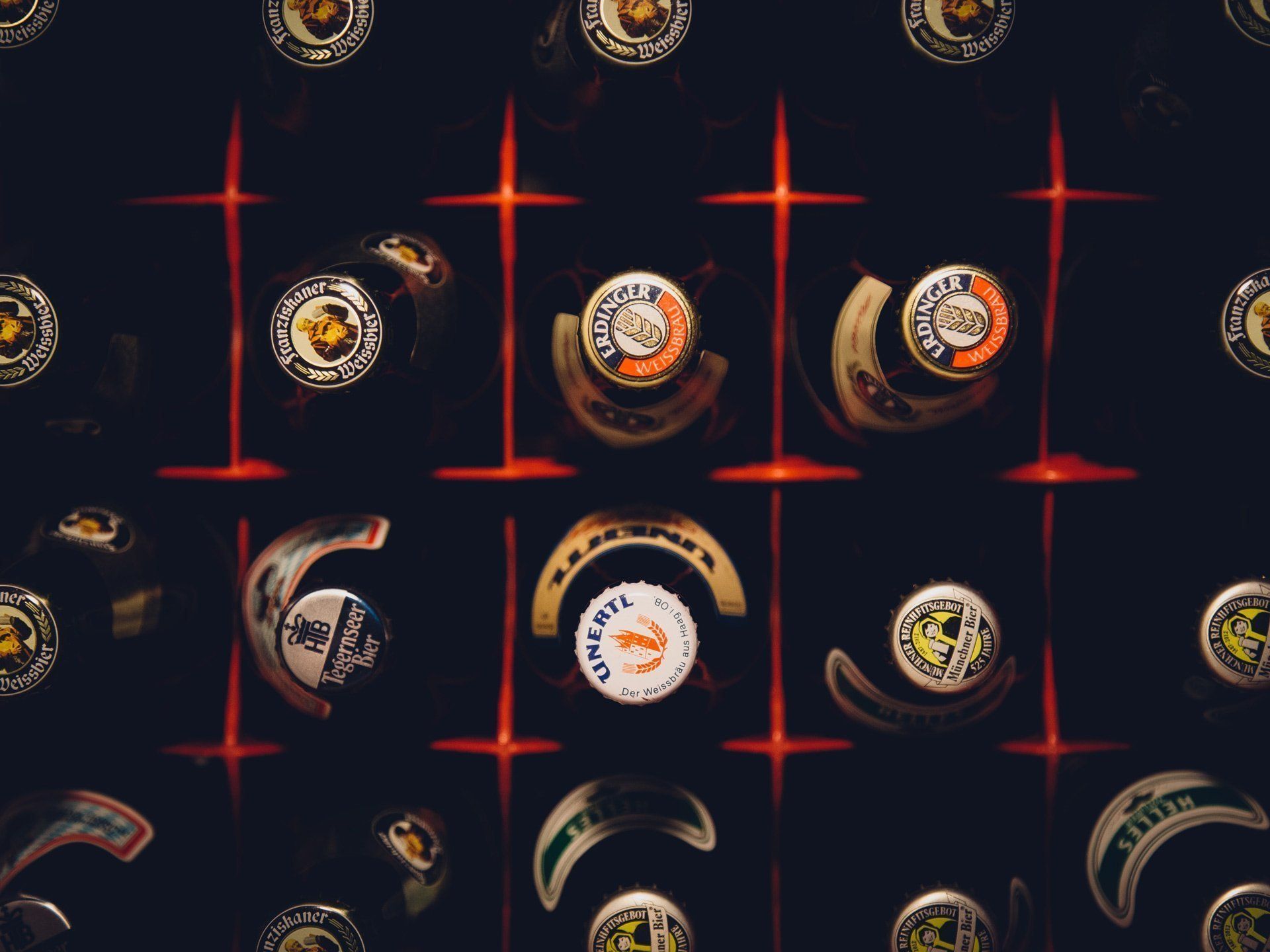 A bunch of beer bottles are lined up in a grid