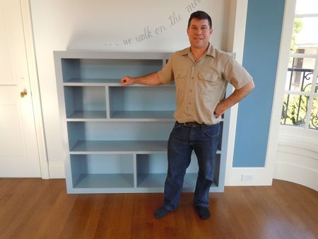 A man standing in front of a bookshelf 