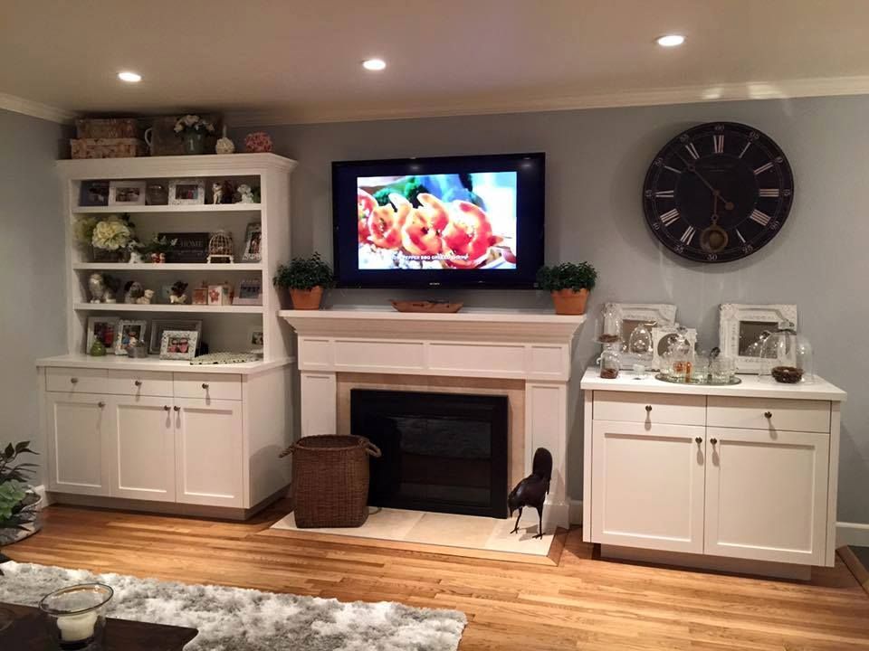 A living room with a fireplace and a flat screen tv on the wall.
