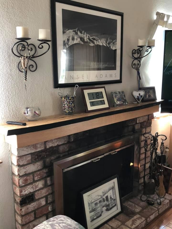 A living room with a fireplace and a picture on the mantle.