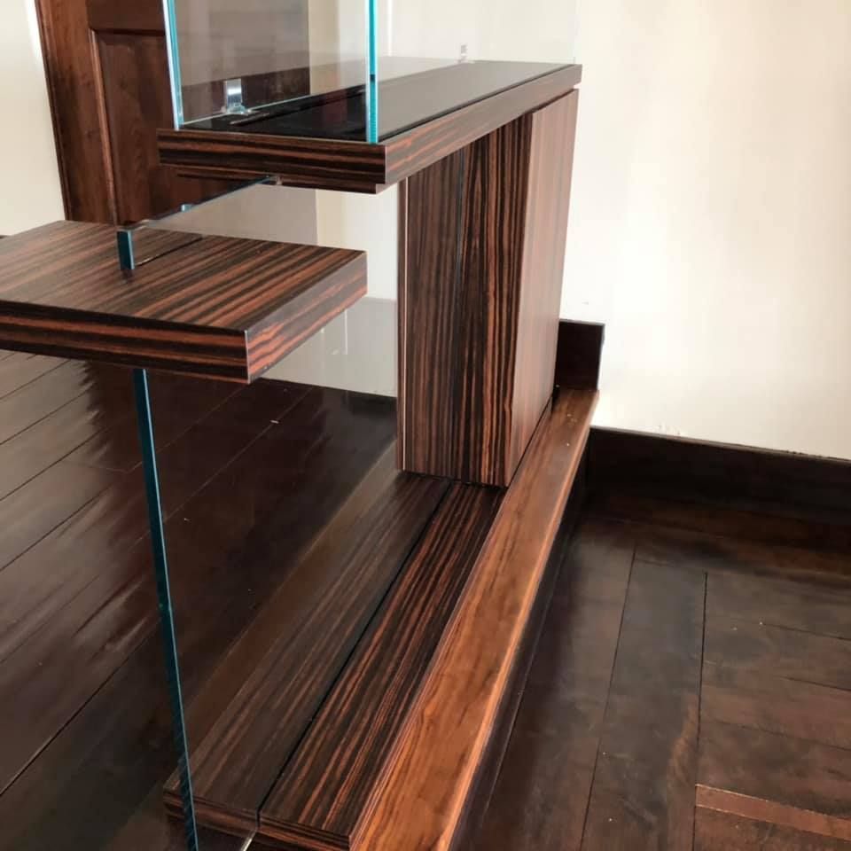 A wooden shelf with glass shelves in a room