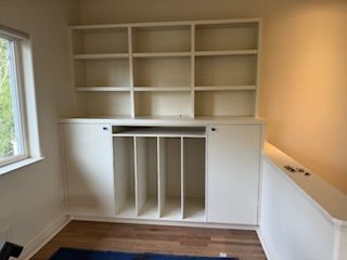 A room with white shelves and a window