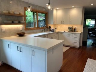 A kitchen with white cabinets and a large island in the middle.
