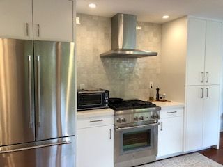 A kitchen with stainless steel appliances and white cabinets.