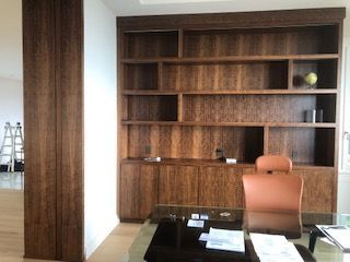 A room with a desk and shelves and a chair