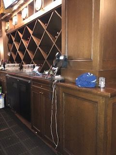 A bar with a lot of shelves and a blue hat on the counter.
