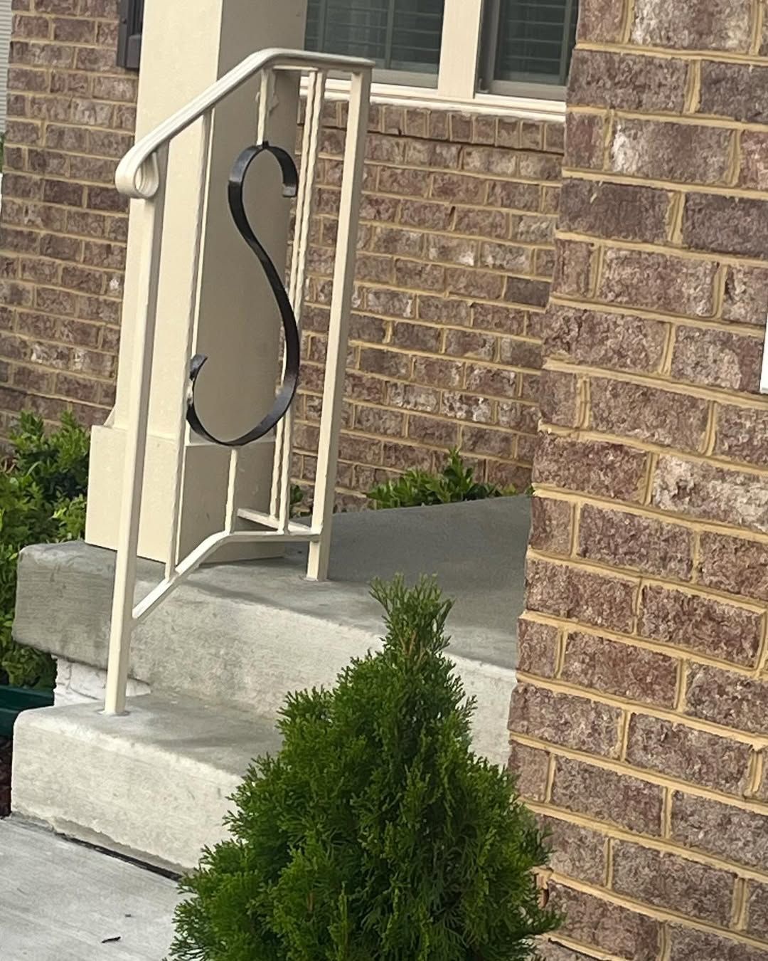 A white railing with a letter s on it
