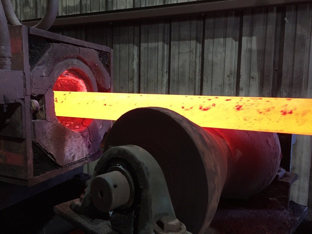 A large piece of metal is being heated in a furnace.