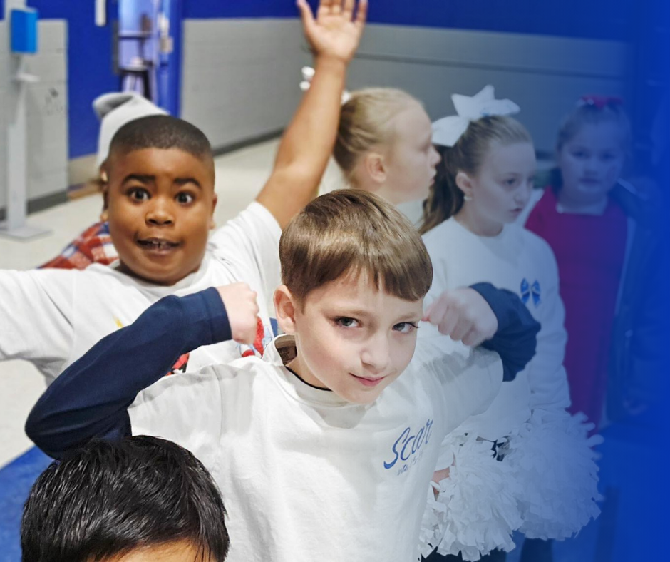 Children posing and cheering in a school hallway with a blue background.