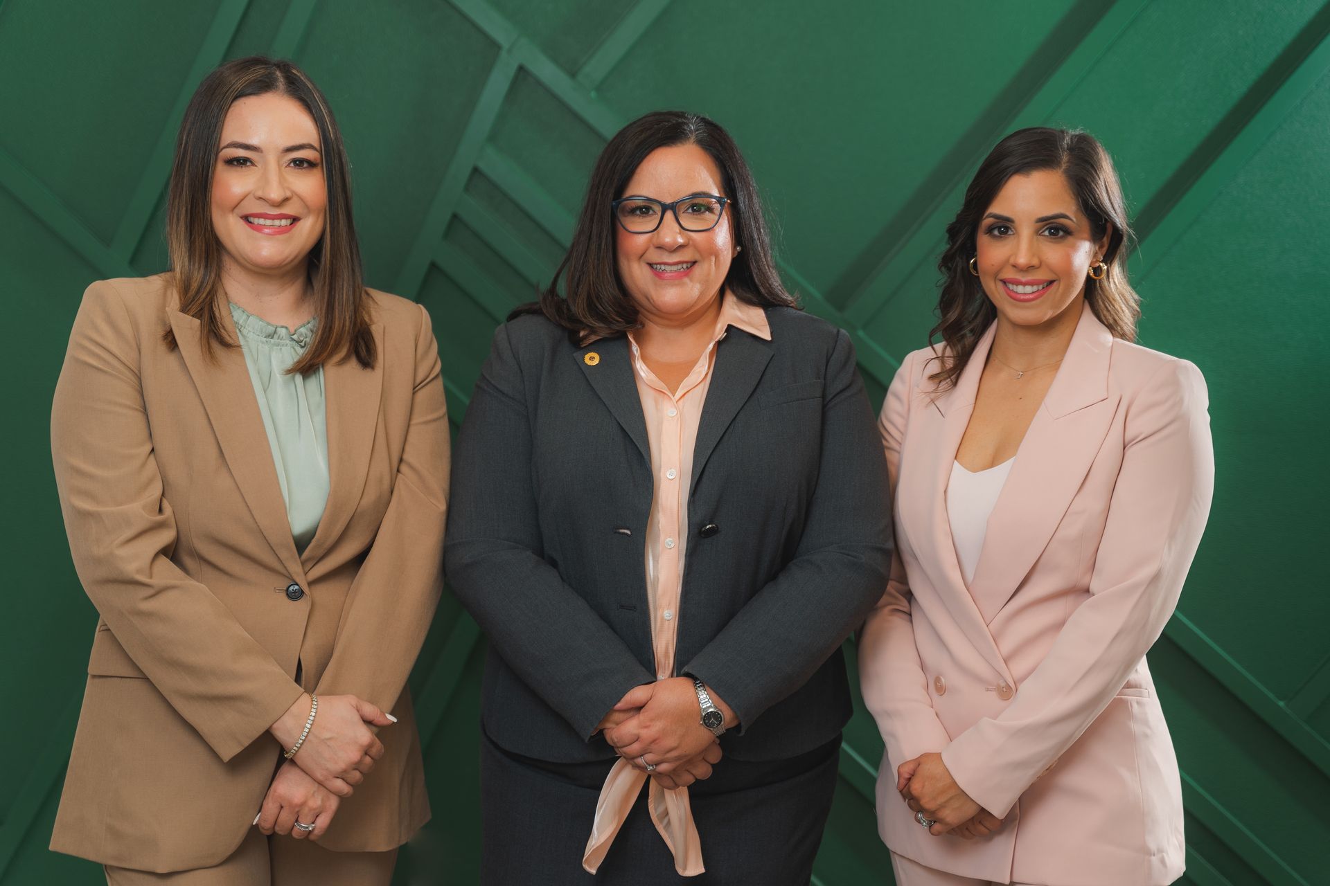 Three women in business suits are posing for a picture.