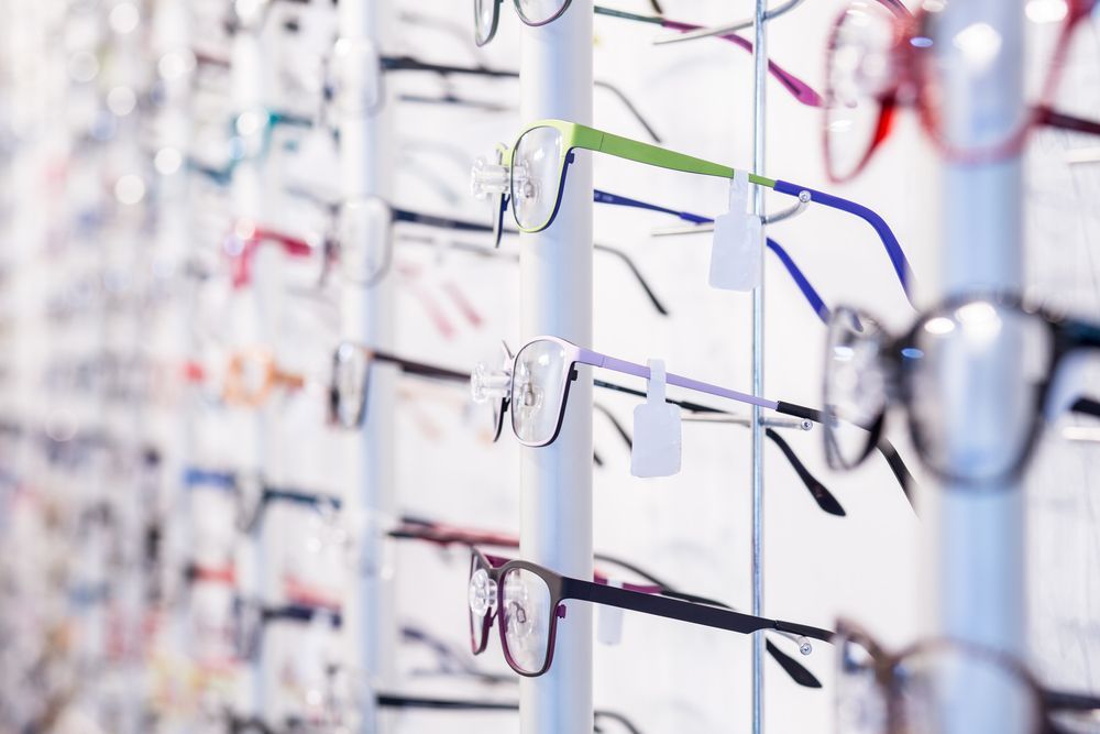 Eyeglasses Displayed on a White Rack in an Optical Store — EyeMax EyeCare in Wallsend, NSW