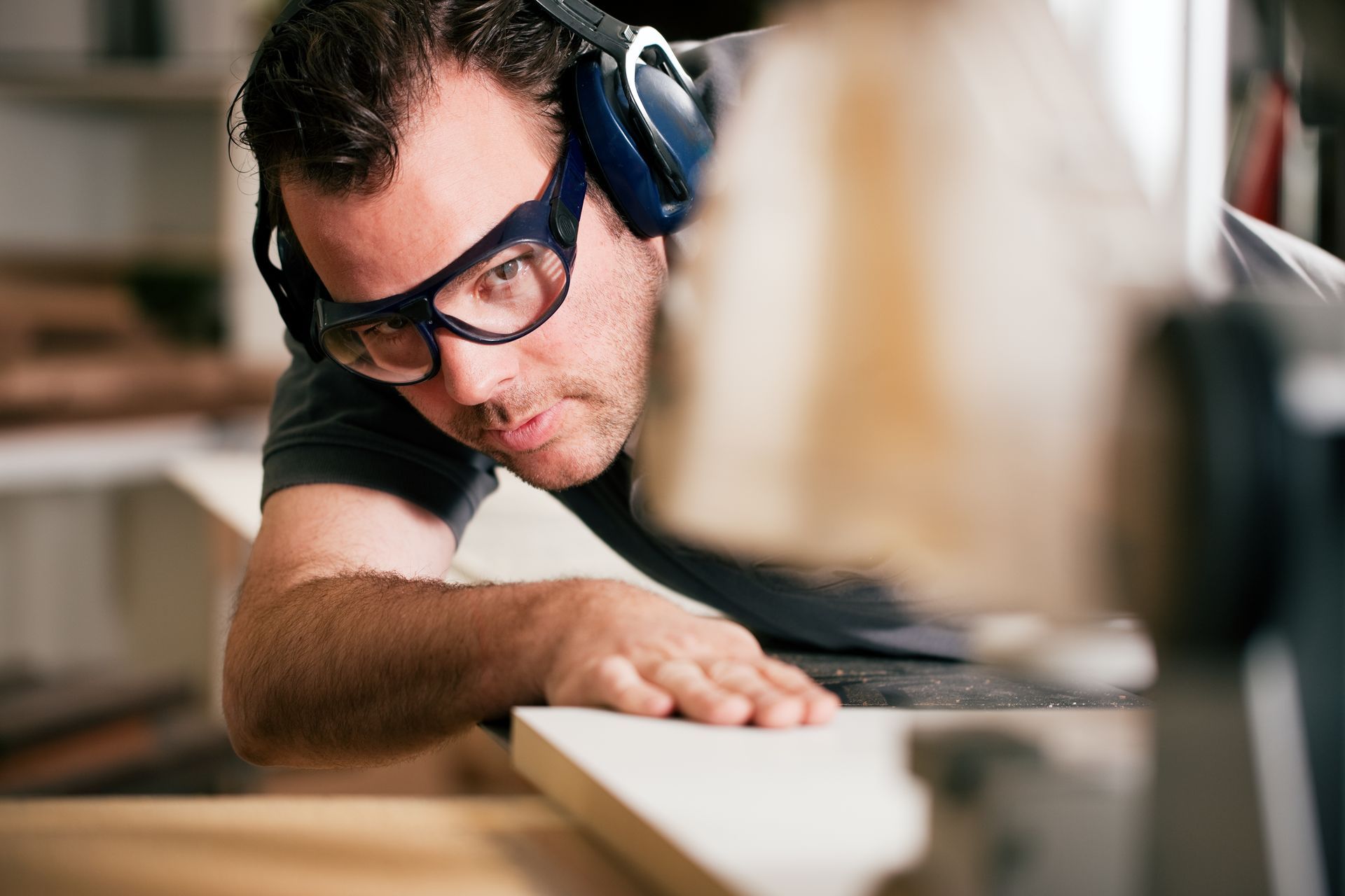 Man Wearing Safety Glasses and Ear Protection Operating a Saw — EyeMax EyeCare in Maitland, NSW