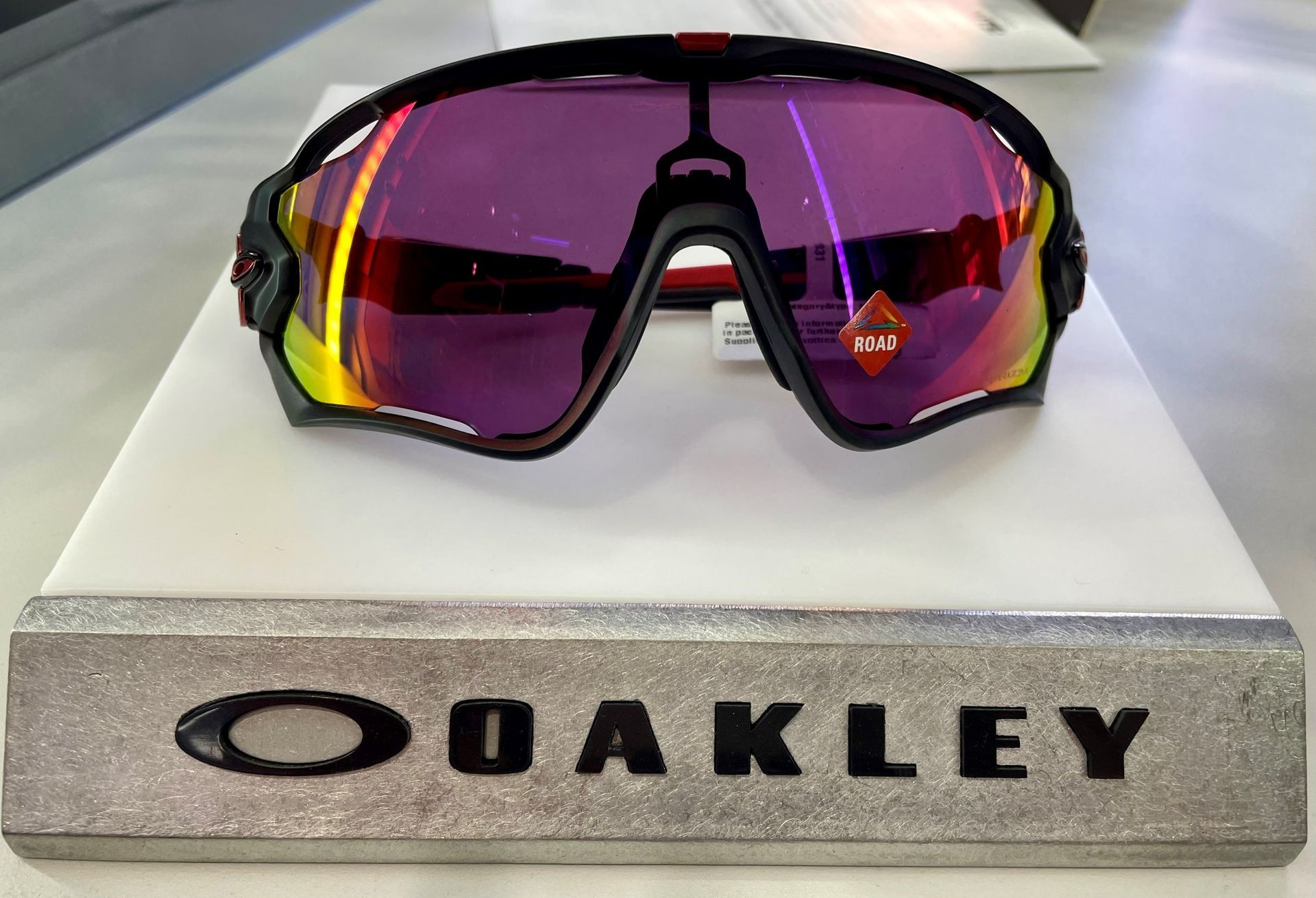 Oakley Sunglasses With Purple Lenses On A Display Stand — EyeMax EyeCare in Maitland, NSW