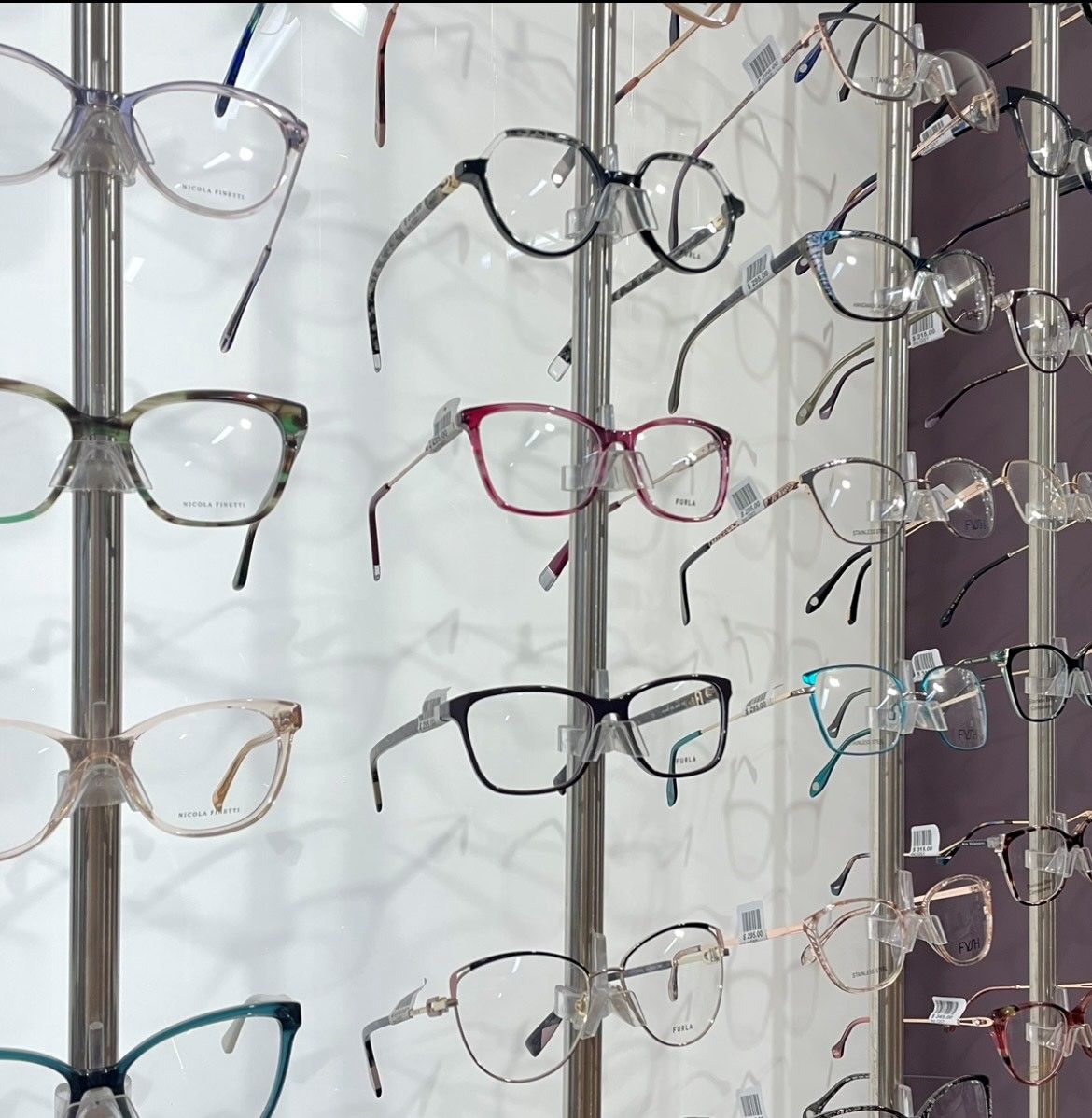 Eyeglasses displayed on a retail wall with various frame styles and colors. — EyeMax EyeCare in Wallsend, NSW