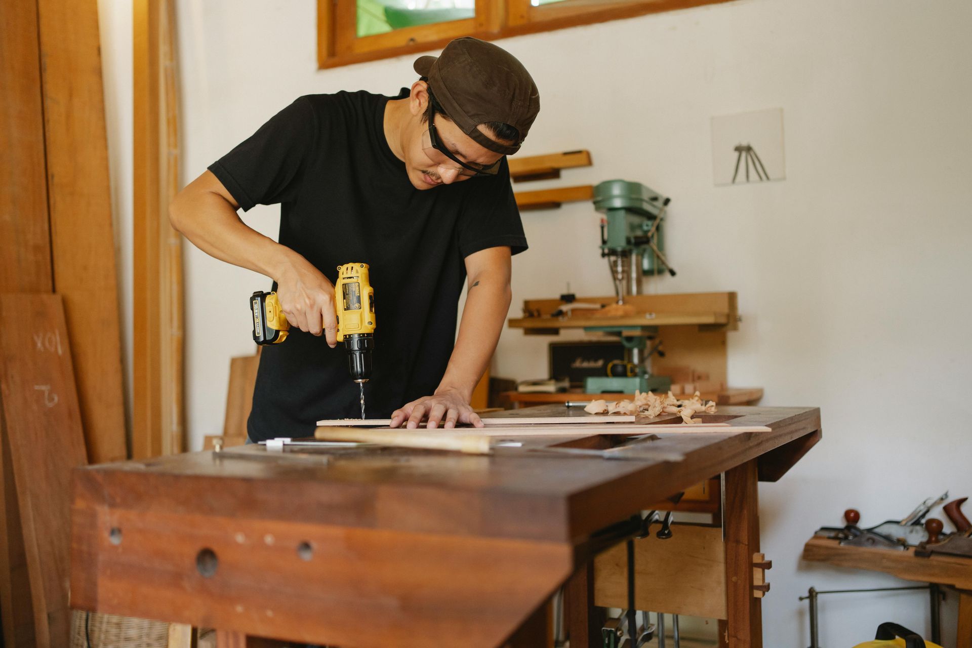Man in Workshop Using a Drill on Wood at Workbench — EyeMax EyeCare in Singleton, NSW