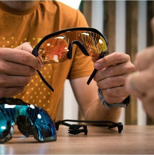 Person Holding Orange-lensed Sunglasses — EyeMax EyeCare in Newcastle, NSW