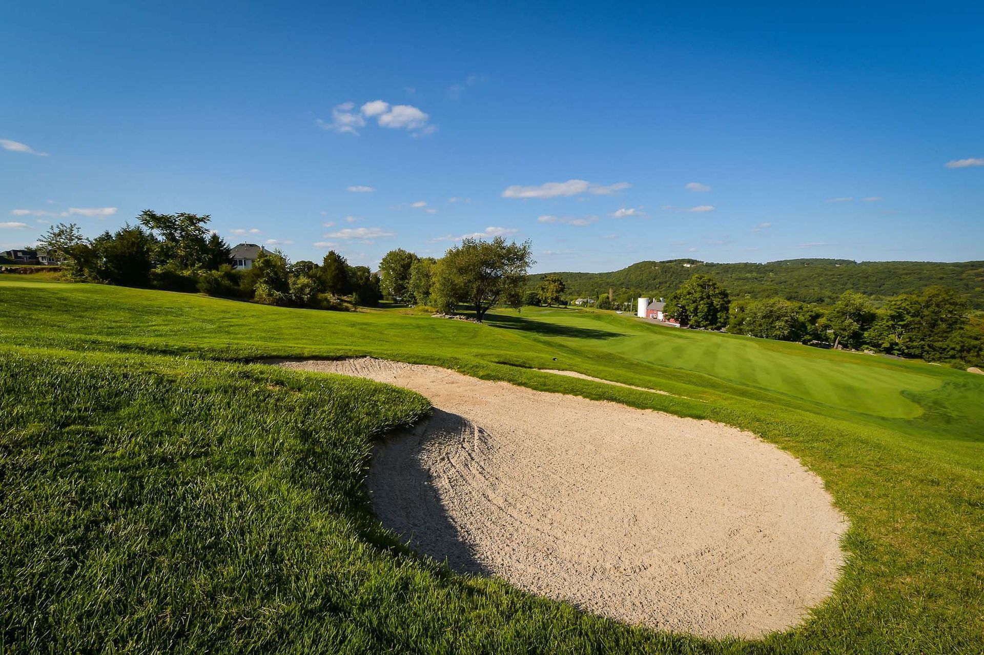 There is a bunker on the side of a golf course.