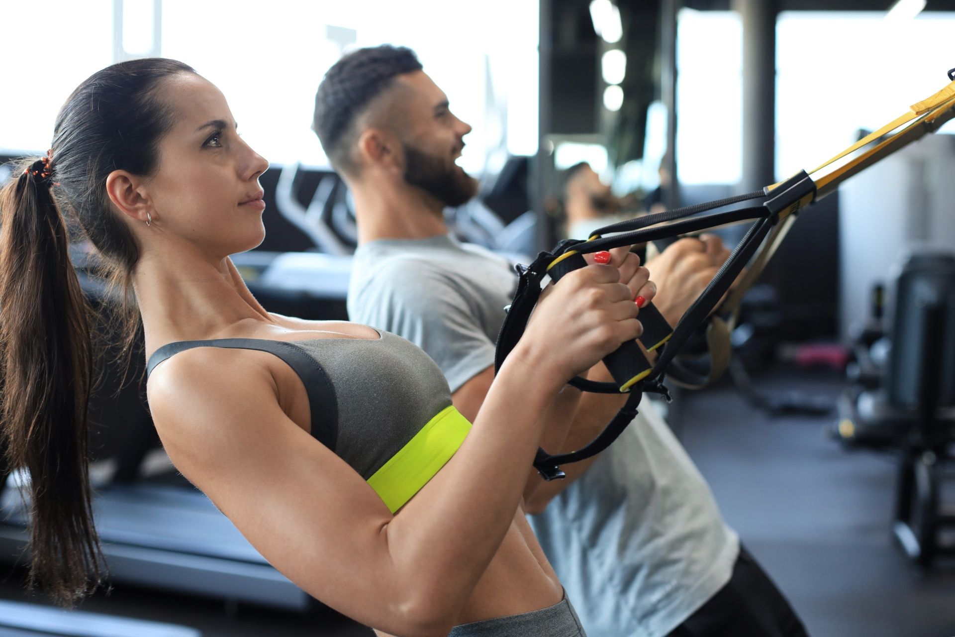 A man and a woman are doing exercises in a gym.