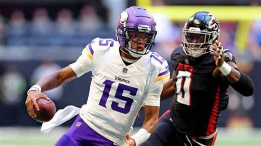 A football player with the number 15 on his jersey is running with the ball.