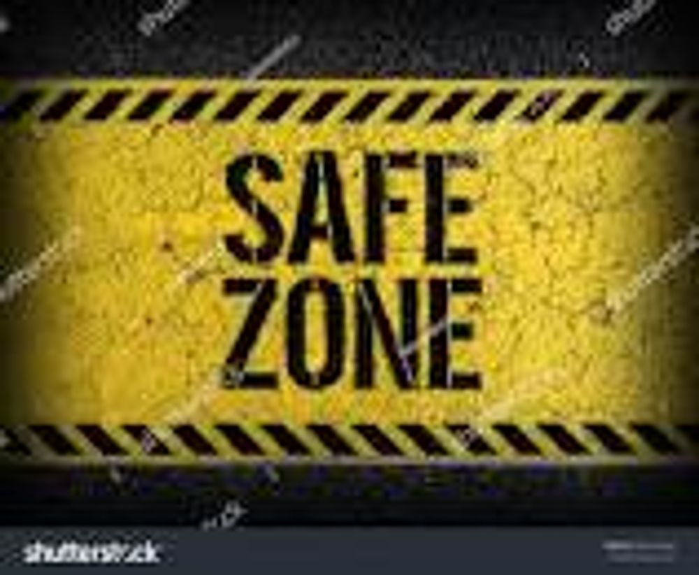 A yellow sign that says `` safe zone '' on a black background.