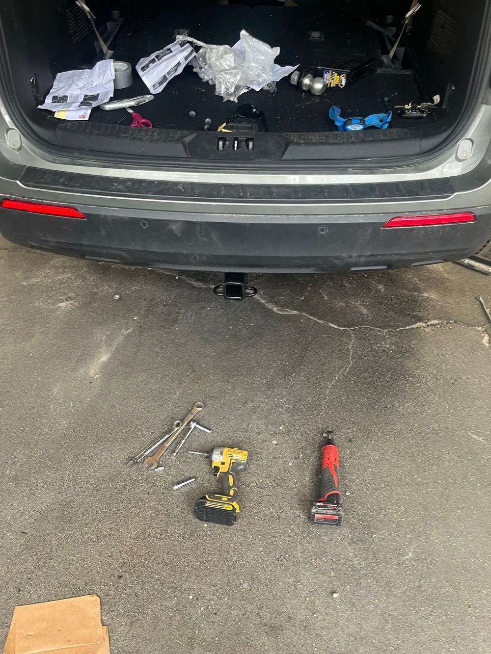 The back of a car is being worked on in a garage.